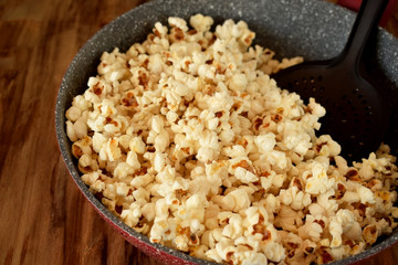 Popcorn in a frying pan on a wooden table
