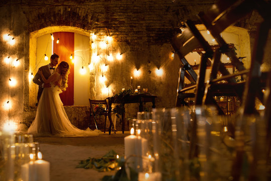 evening stylish wedding couple in rustic decorations and candles
