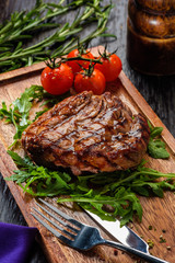 Grilled beef steak on wooden cutting board.
