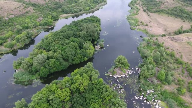 A gorgeous bird`s eye view of the Dnipro river basin with small islets, bubbling inflows, patches of high trees and bulrush on a sunny day