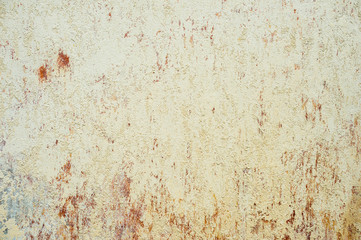Textured background of multi-layer flaking paint on the wall. Mixing different colors of paints in the cleaved layers on the surface. Grunge texture with a deep pattern