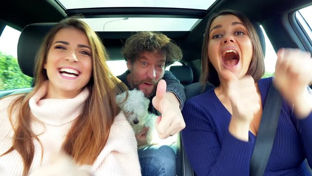 Handsome man and beautiful women driving car showing ok sign success concept