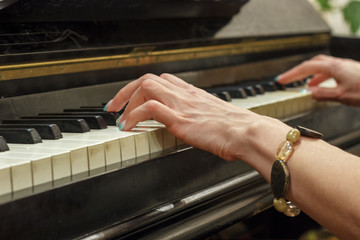 Obraz premium Hands of a girl playing on a white piano, close-up.
