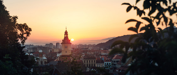 Fototapeta na wymiar Town council hall tower morning sunrise scenic view, location Brasov city, Transylvania, Romania. Famous travel destination scenic summer colorful postcard.
