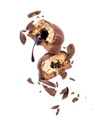 Chocolate cake broken into pieces in the air, isolated on a white background
