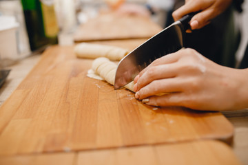 Obraz premium Girl cuts the dough for making Italian pasta
