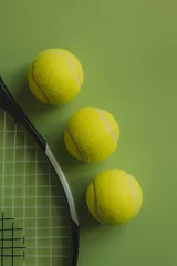 Poster Three tennis balls and a tennis racket on green background. © daviles