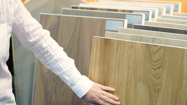 Blonde woman chooses top samples of various color palette at exhibition or in a store