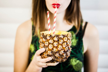 Portrait of young beautiful woman drinking fresh pineapple cocktail.