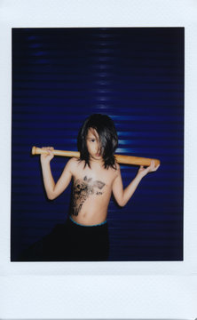 Instant mini film photo of a mad kid with baseball bat