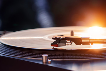 Turntable vinyl record player on the background of a sunset over the lights city. Sound technology for DJ to mix & play music. Black vinyl record. Vintage vinyl record player. Needle on a vinyl record - 194481857