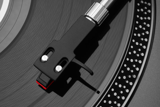 Turntable vinyl record player. Sound technology for DJ to mix & play music. Needle on a vinyl record close-up. Vinyl record player on a background decorations for a party, bright disco lights        