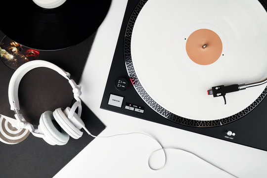 Turntable vinyl record player and white headphones on the background white wooden boards. Sound technology for DJ to mix & play music. White vinyl record                      