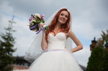 Fototapeta na wymiar Smiling bride holding wedding bouquet