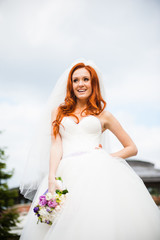 Fototapeta na wymiar Smiling bride holding wedding bouquet