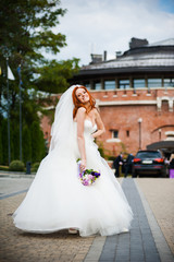 Obraz premium Fashion bride girl in gorgeous wedding dress with wedding bouquet of flowers