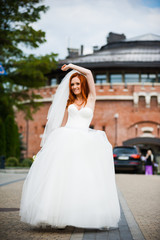 Fototapeta premium Fashion bride girl in gorgeous wedding dress with wedding bouquet of flowers