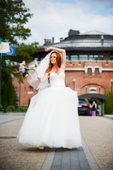 Obraz premium Fashion bride girl in gorgeous wedding dress with wedding bouquet of flowers