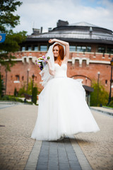 Fototapeta premium Fashion bride girl in gorgeous wedding dress with wedding bouquet of flowers