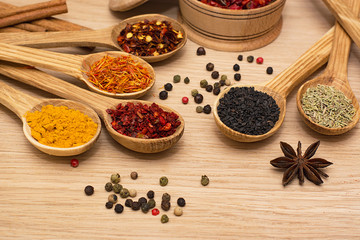 Spice. Spice in a wooden spoon. Herbs. Curry, saffron, turmeric, pepper and others on a wooden background.