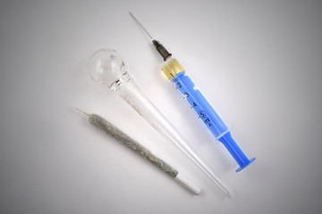 Syringe, joint, glass pipe stock photo images. Oil pipe, marijuana cigarette and syringe on a white...