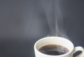 Hot coffee with smoke ready to drink on a gray background with e