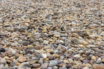 Stones and pebbles background. Gravel and granite surface. Beach and shore closeup background. Mineral pattern concept. 