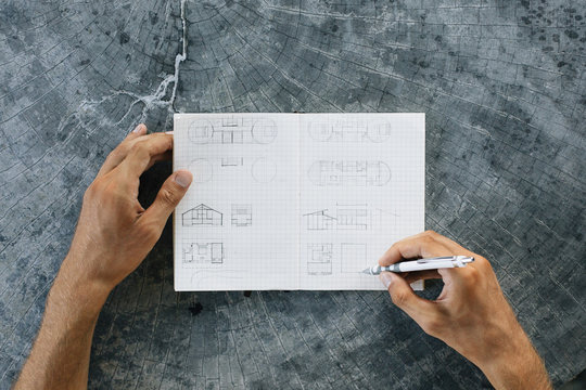 Man drawing sketches in note book