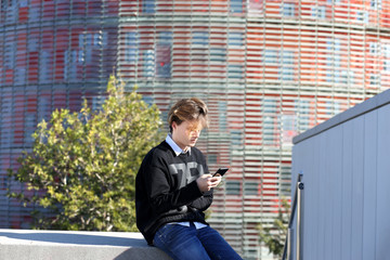 Teenage boy typing text message.Using smart phone