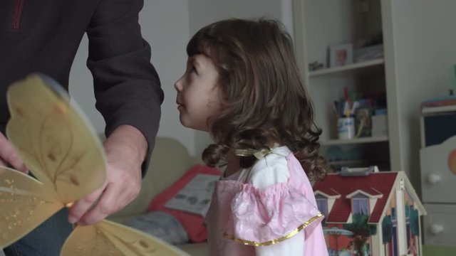 Nice candid child dressing up by her dad like a pink fairy with little wings (slow motion)