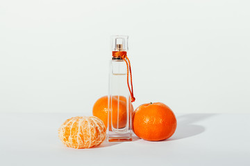 Bottle of toilet water and tangerines on a table