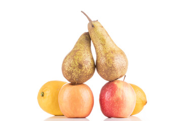 Zitrone Apfel Birne gestapelt vor weißem Hintergrund
