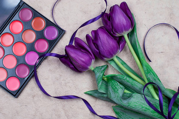 Three lilac tulips and a palette of blush with a purple ribbon.