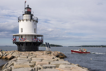 Fototapeta na wymiar Lobster Boat Passes by Spring Point Lighthouse in Maine.