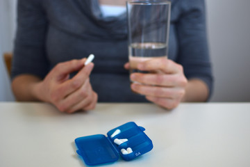 Einnahme von Medikamenten, Tablette mit einem Schluck Wasser