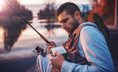 Fotobehang Visser geniet van vissen op de rivier. Sport, recreatie, levensstijl © bobex73