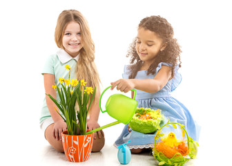 two little girls watering flowers and playing on the floor