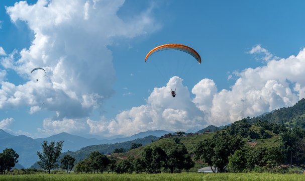 landing with parachute after paragliding in Nepal