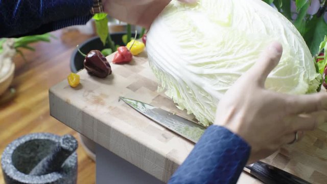placing a nappa cabbage on a cutting board to prepare for cooking