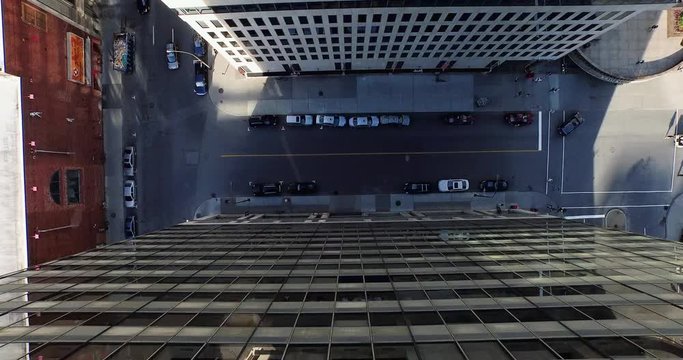 aerial drone descent between glass city office buildings