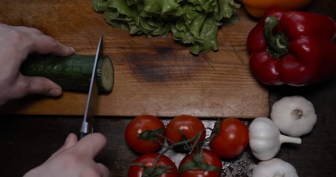 Kitchen table with vegetables, cucumber, red, yellow pepper, tomato, green salad, champignons, garlic knife....