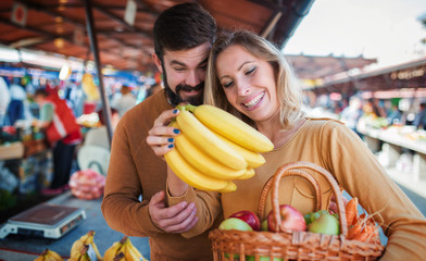 Young couple buying at street market. Lifestyle, consumerism, shopping