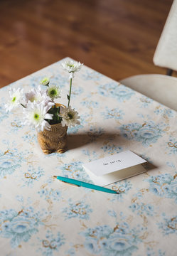 Card next to flowers on a table
