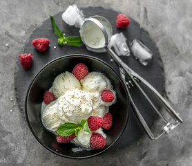ice cream with raspberries served in black piala