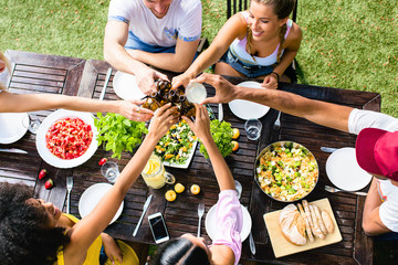 Group of young friends toasting beer's in a summer lunch.