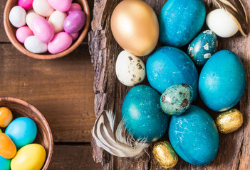 Fototapeta na wymiar Easter holiday background.Easter colored eggs and sweets on rustic wooden background.
