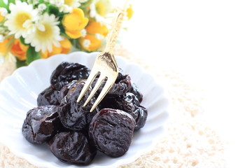 Dried fruit, prune on white dish with copy space for healthy food image
