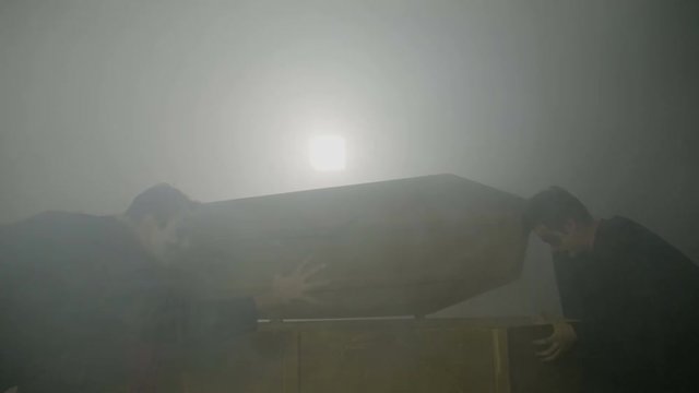 Zombies waking up female creepy vampire opening her coffin on a foggy night and performing a halloween ritual