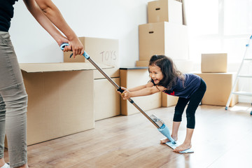 Adorable girl playing with her mother at new home