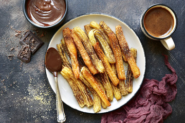 Churros - traditional mexican dessert with chocolate sauce.Top view .